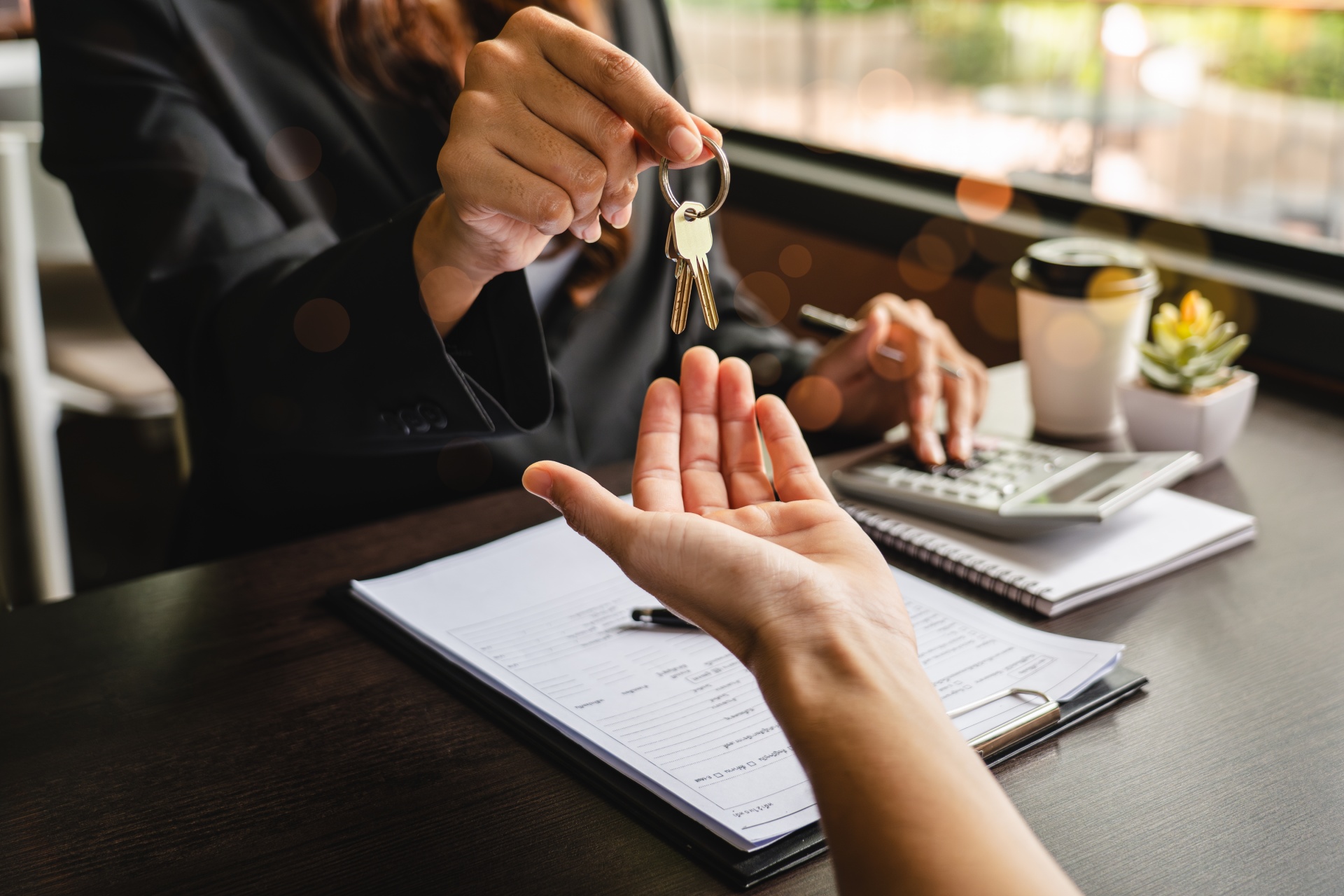 Broker handing home keys to client